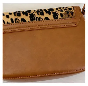 Close-up of leopard print edge and premium brown leather texture on shoulder bag
