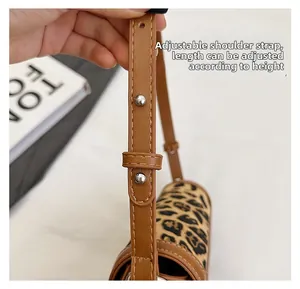 Detail of adjustable brown strap with silver buckle on leopard print shoulder bag