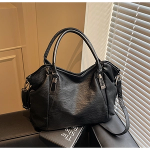 Close-up of soft black leather tote bag showing textured surface and silver hardware details