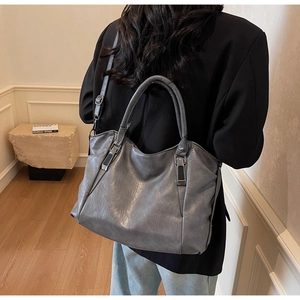 Detail of grey PU leather tote bag with silver hardware and adjustable shoulder strap