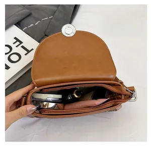Interior view of brown leather saddle bag showing ample space for cosmetics and essentials