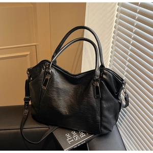 Detailed view of black faux leather tote bag with vintage pleated texture and gunmetal hardware