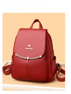 Detail of red faux leather backpack showing litchi texture and golden kangaroo logo