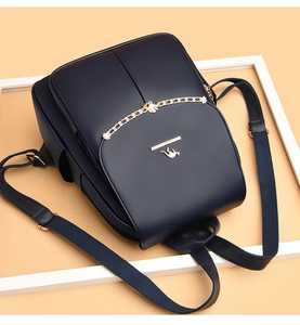 Detail of navy blue soft leather backpack featuring golden kangaroo logo and metal chain