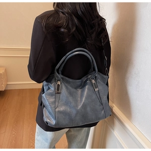 Chic smog blue tote bag showing soft leather texture and stylish round handle design