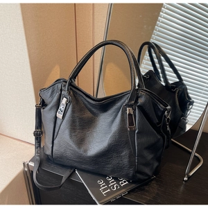 Close-up of black lychee texture tote bag with silver hardware and adjustable strap
