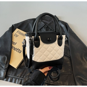 Dettaglio della borsa in pelle trapuntata con contrasto bianco e nero e grana litchi