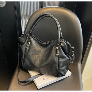 Close-up of black PU leather tote bag with lychee texture and gun-grey metal hardware