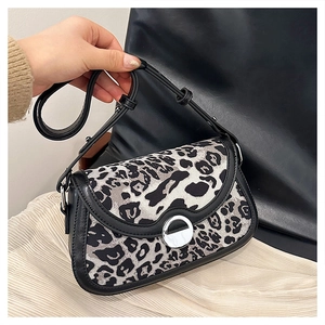 Close-up of leopard print shoulder bag featuring silver ring buckle and black leather trim