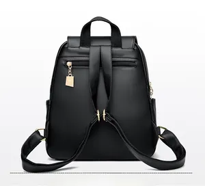 Back view of black leather backpack with anti-theft zipper and golden hardware