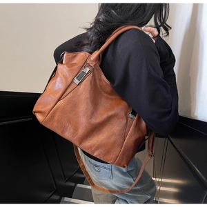 Brown faux leather tote bag showing fine pleated texture and silver buckle details