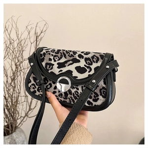 Detailed view of leopard print handbag with silver circular clasp and black leather edges