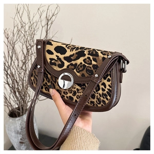 Close-up of leopard print texture and brown leather strap on vintage women bag