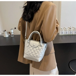 Vista posteriore di modella con borsa trapuntata argento e tracolla regolabile