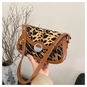 Detail of vintage leopard print flap bag with brown leather trim and silver buckle