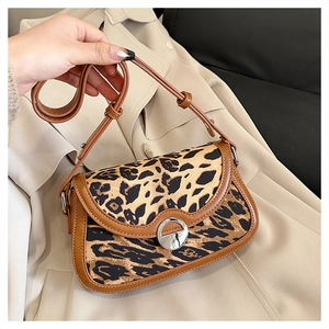 Close-up of leopard print fabric detail with brown faux leather trim and silver metal lock
