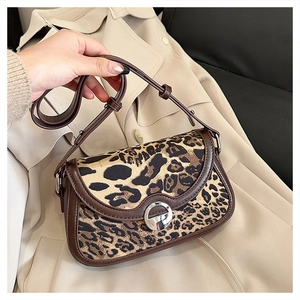 Detail of leopard print shoulder bag featuring a silver metal twist lock on beige trench coat