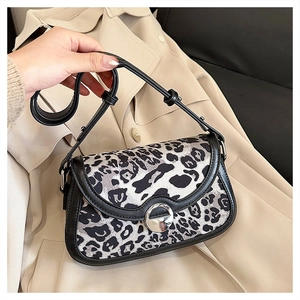 Detail of leopard print crossbody bag with silver metal lock and black leather strap