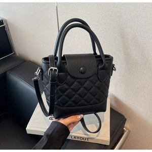Dettaglio borsa a secchiello in pelle nera a grana con eleganti cuciture a rombi