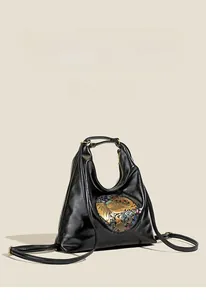 Detail of black vintage leather backpack with colorful elephant embossed emblem