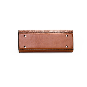 Brown leather tote bag featuring a textured finish and protective metal feet on base