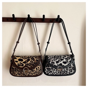 Detail view of two leopard print handbags with silver buckles and leather straps