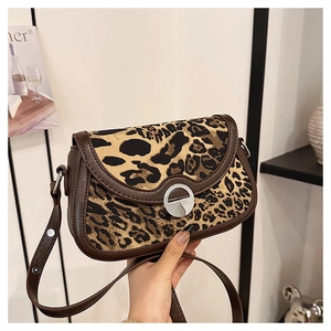 Detail of leopard print crossbody bag with silver metal ring clasp and brown leather trim