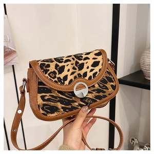 Detail of leopard print flap bag with brown leather trim and silver metal buckle