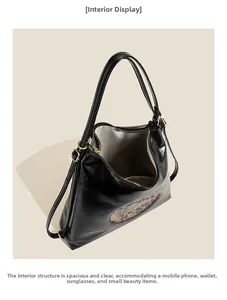 Top view of open black shiny backpack showing spacious grey lining for daily essentials
