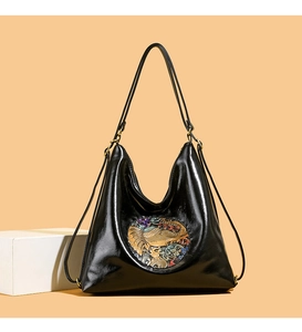 Close-up of elephant relief and glossy leather texture on women's black backpack