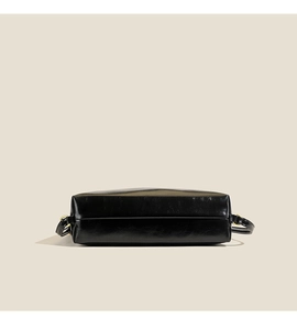 Detailed bottom view of black faux leather backpack featuring golden metal rings