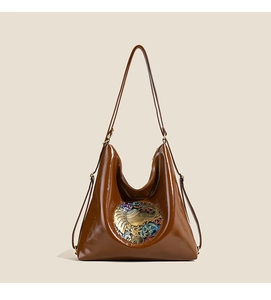 Detail of vintage brown leather hobo bag with artistic elephant relief and glossy finish