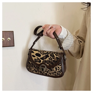 Detail of vintage leopard print shoulder bag with brown leather trim and silver metal clasp