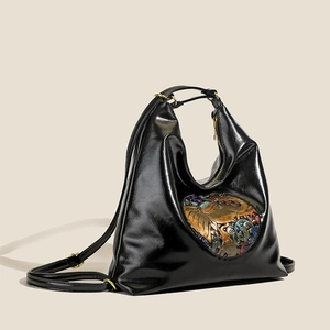 Women's black leather backpack with embossed elephant heart design and vintage gold hardware