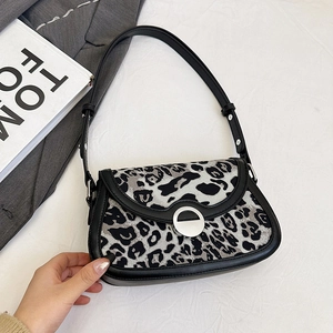 Leopard print shoulder bag with silver buckle and leather trim on minimalist background