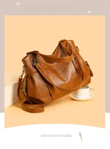 Close-up of caramel brown PU leather tote bag with soft texture and side zipper detail