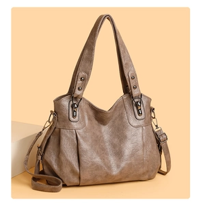 Macro detail of tan PU leather tote with vintage texture and bronze metal hardware