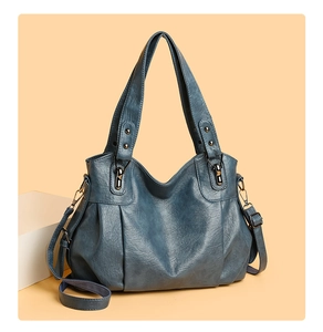 Detail view of deep blue PU leather tote bag with vintage texture and gold studs