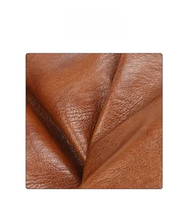 Close-up of brown PU leather with lychee texture and soft folds on a tote bag