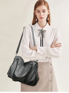 Detail of black large capacity PU tote bag showing leather texture and side rivet accents