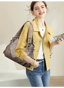 Detail of dark brown vintage faux leather hobo bag with silver studs on model
