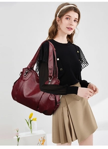 Deep red PU leather tote bag showing spacious design and silver metal buckle details