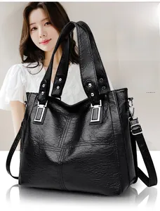 Gros plan d'un sac cabas noir en cuir PU avec texture grainée et boucles argentées en métal