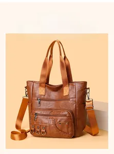 Detail of vintage brown tote bag showing multiple zipper pockets and texture