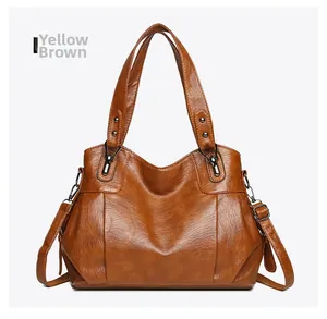 Detail of yellow brown PU leather tote bag with vintage texture and adjustable strap
