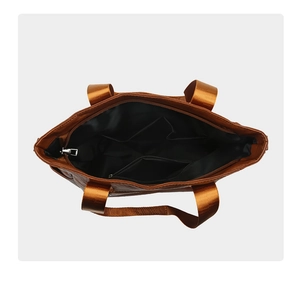 Detailed interior of brown tote bag showing spacious compartments and zip pocket