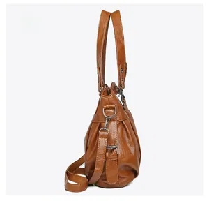 Side view of caramel brown oil-waxed PU tote bag with silver hardware and adjustable strap