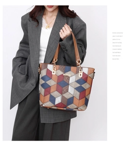 Macro detail of 3D geometric tote bag with colorful patchwork and gold metal hardware