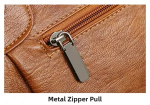 Macro view of high-quality metal zipper pull and textured brown leather on tote bag
