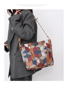 Detail of color-block tote bag with pebble leather texture and gold chain handle